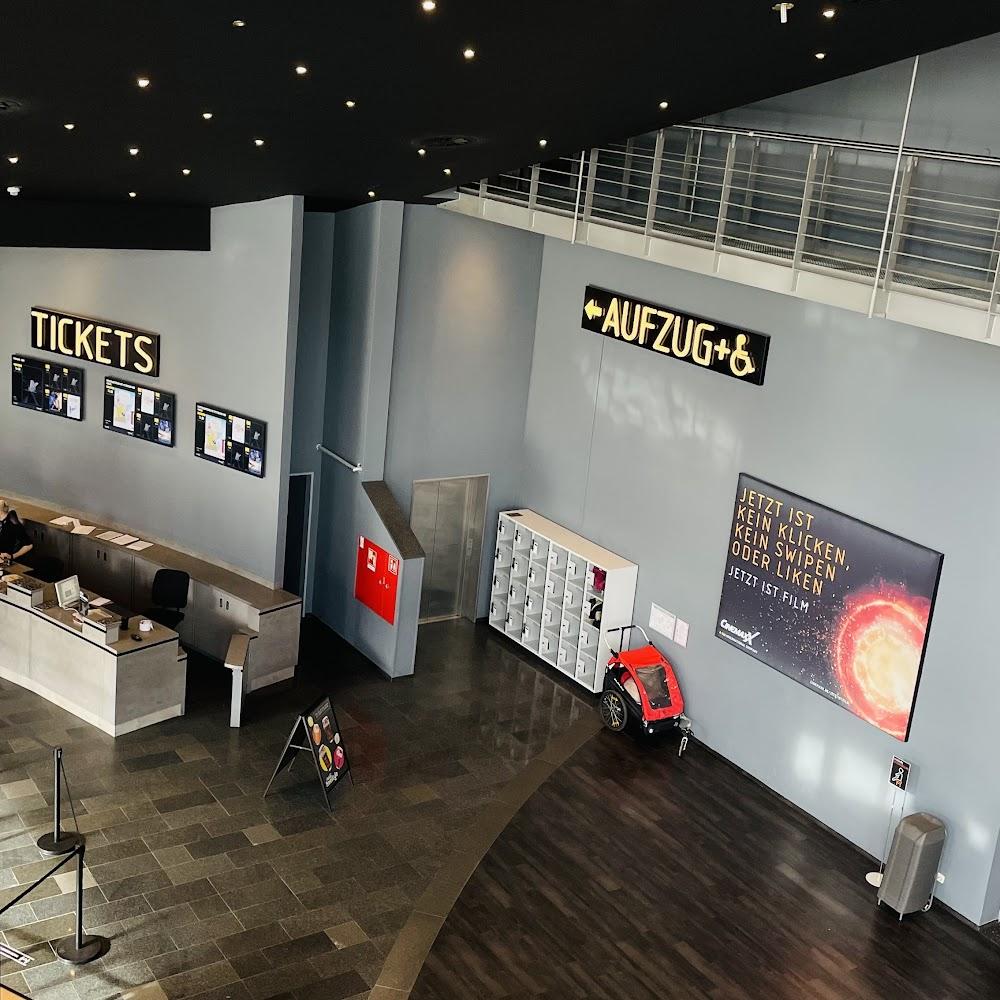 A movie theatre lobby with a ticket counter and a sign that says